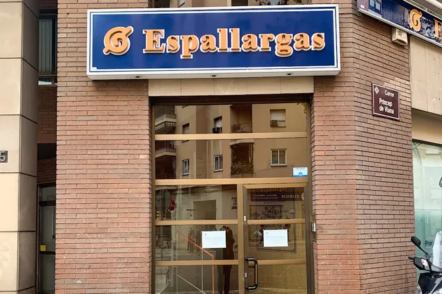 L'entrada · A peu de carrer, sota el rètol blau i taronja